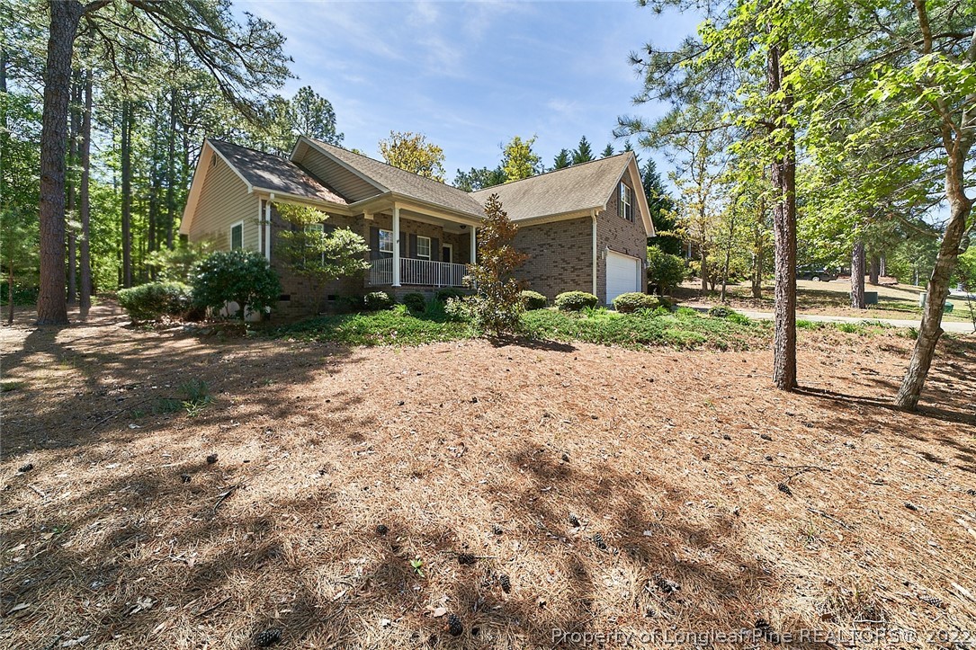 60 Spring Lake Drive Pinehurst, NC 28374 - Photo 4 of 38 a front view of a house with a yard and potted plants