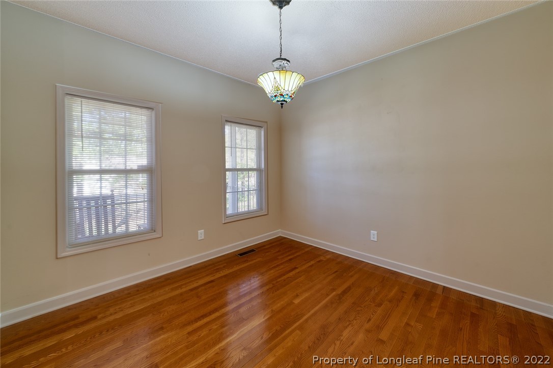 60 Spring Lake Drive Pinehurst, NC 28374 - Photo 10 of 38 a view of an empty room with a window and wooden floor