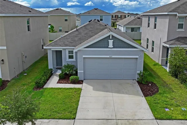 an aerial view of a house with a garden and lake view