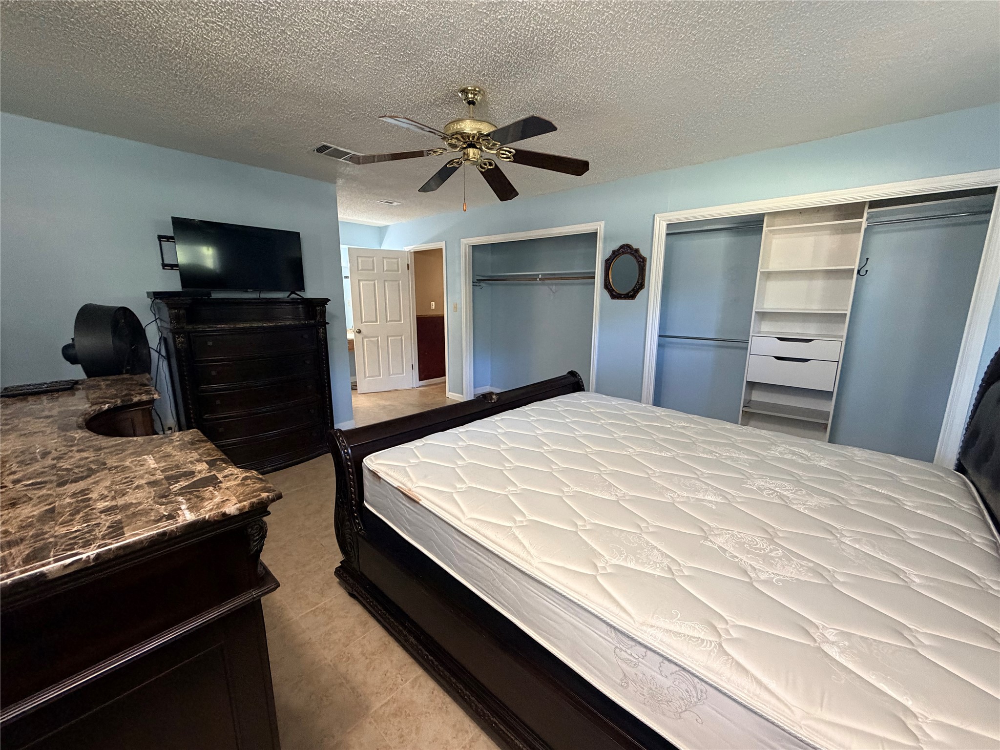 Double closets with built-in shelving complement this comfortable bedroom layout.