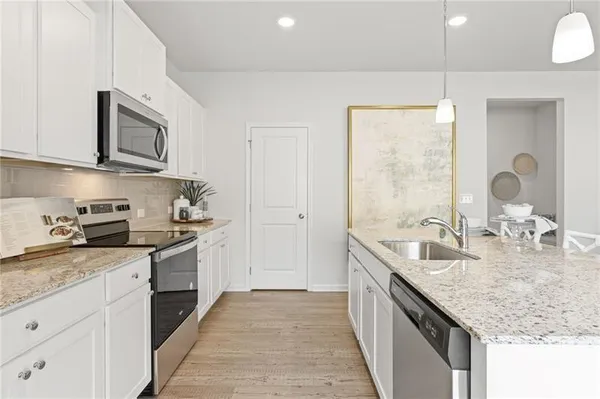 a kitchen with stainless steel appliances granite countertop a sink stove and cabinets