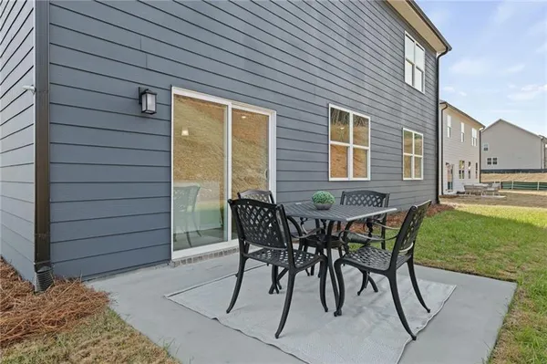 a patio with table and chairs and garden
