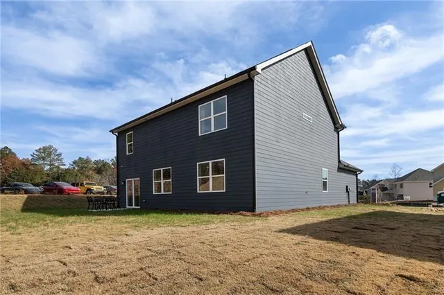 a view of backyard of house with wooden fence