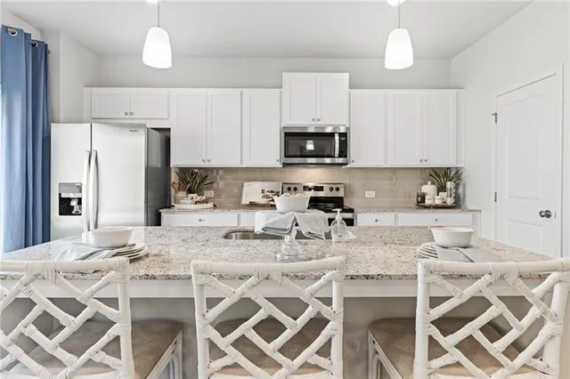 a kitchen with stainless steel appliances kitchen island granite countertop a sink and cabinets