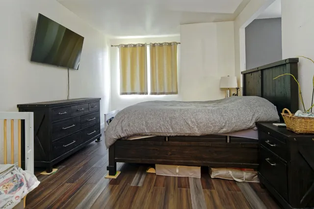 a bedroom with a bed and flat screen tv