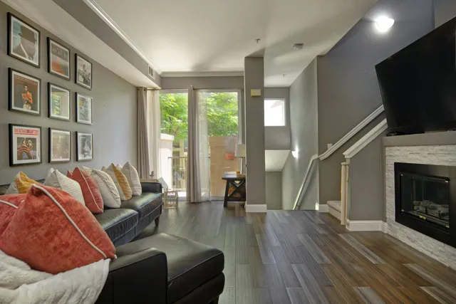 a living room with furniture a flat screen tv and a fireplace