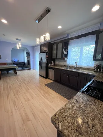 a large kitchen with kitchen island a sink stainless steel appliances and cabinets