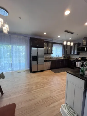 a large kitchen with stainless steel appliances kitchen island granite countertop a sink and cabinets