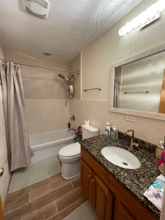 a bathroom with a granite countertop sink toilet and shower