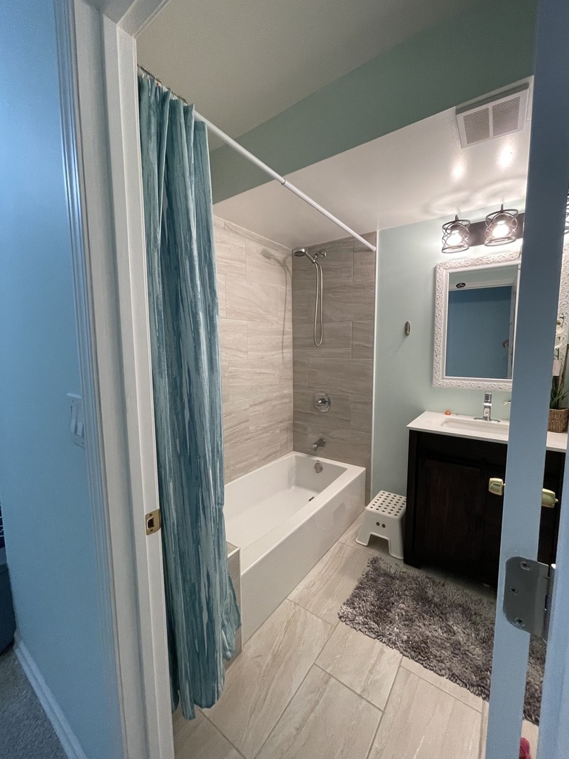 200 Thacker Street West Hoffman Estates, IL 60169 - Photo 3 of 15 a bathroom with a tub sink and mirror