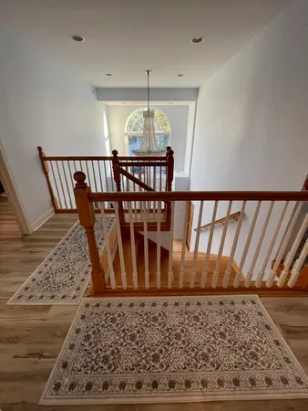 a view of a hallway and a dining room with wooden floor
