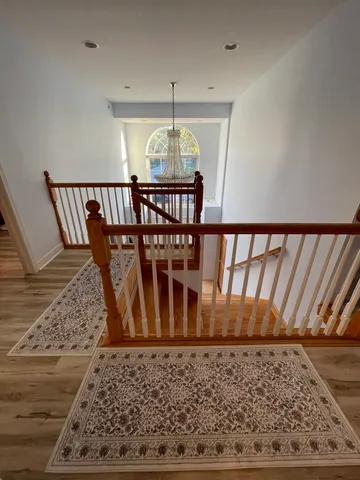 a view of a hallway and a dining room with wooden floor