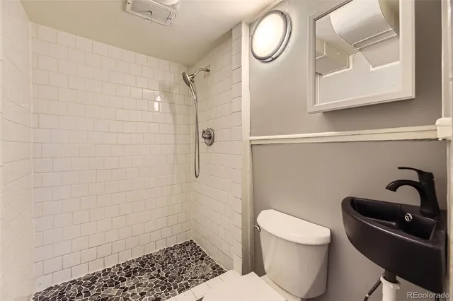 a bathroom with a sink a toilet and a shower