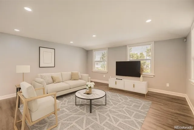 a living room with furniture a flat screen tv and a window