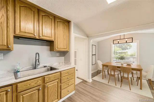 a kitchen with stainless steel appliances granite countertop wooden cabinets a table and chairs
