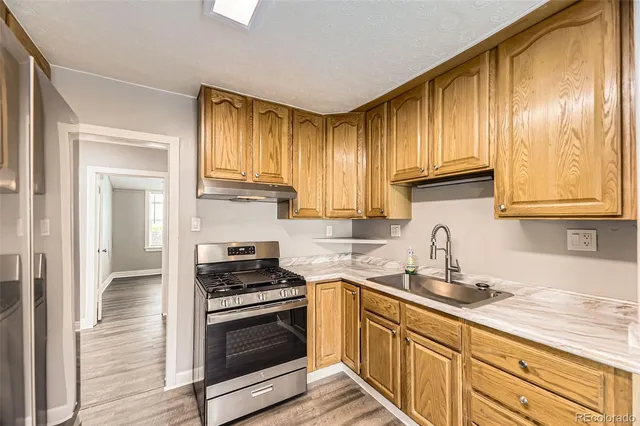 a kitchen with granite countertop cabinets stainless steel appliances and a window