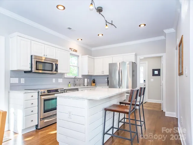 a kitchen with kitchen island a stove a sink and a refrigerator