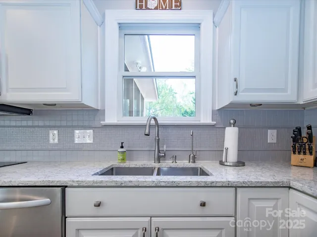 a kitchen with granite countertop a sink and a window