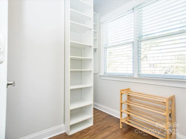 a view of a bedroom with a window and wooden floor
