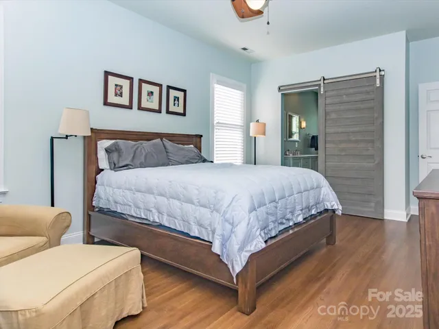 a bedroom with a bed and glass walk in closet