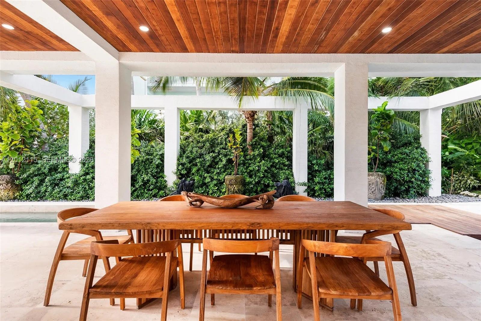 60 Ocean Front Drive Key Largo, FL 33037 - Photo 20 of 85 a view of a patio with table and chairs under an umbrella with a small yard