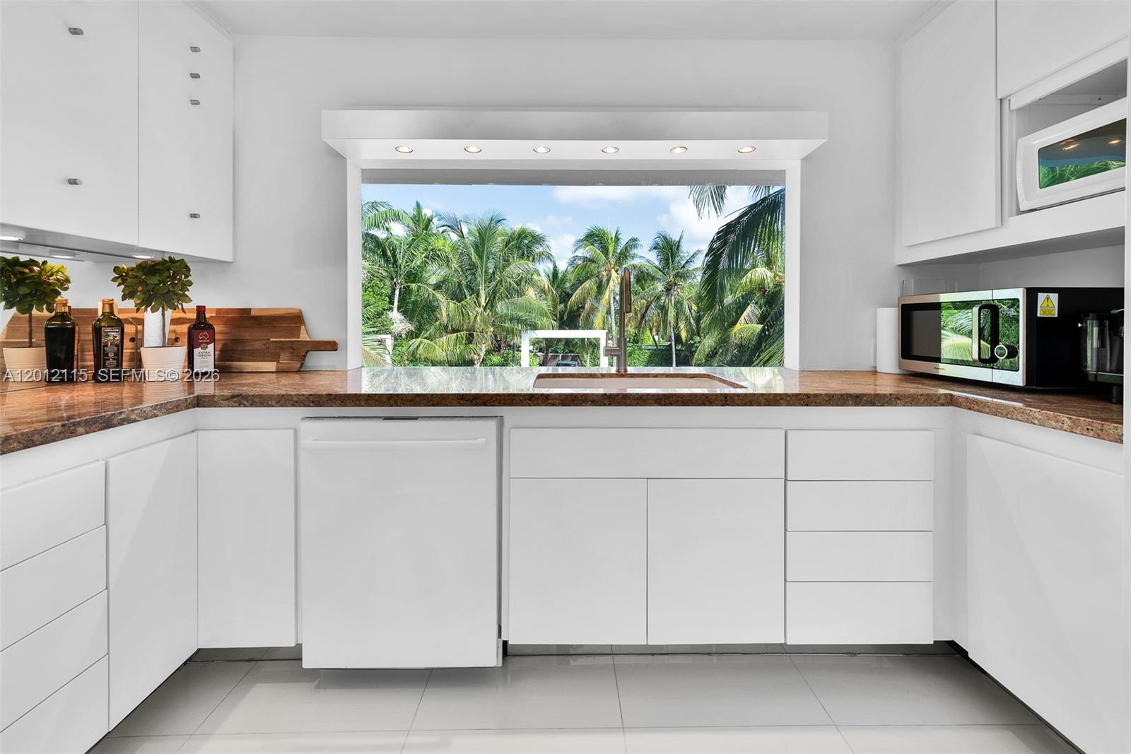 60 Ocean Front Drive Key Largo, FL 33037 - Photo 57 of 85 a kitchen with granite countertop white cabinets and a large window