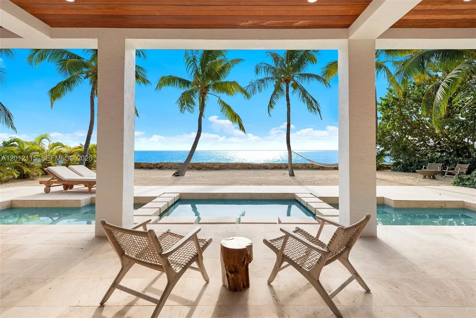 60 Ocean Front Drive Key Largo, FL 33037 - Photo 6 of 85 a view of a patio with a table and chairs potted plants
