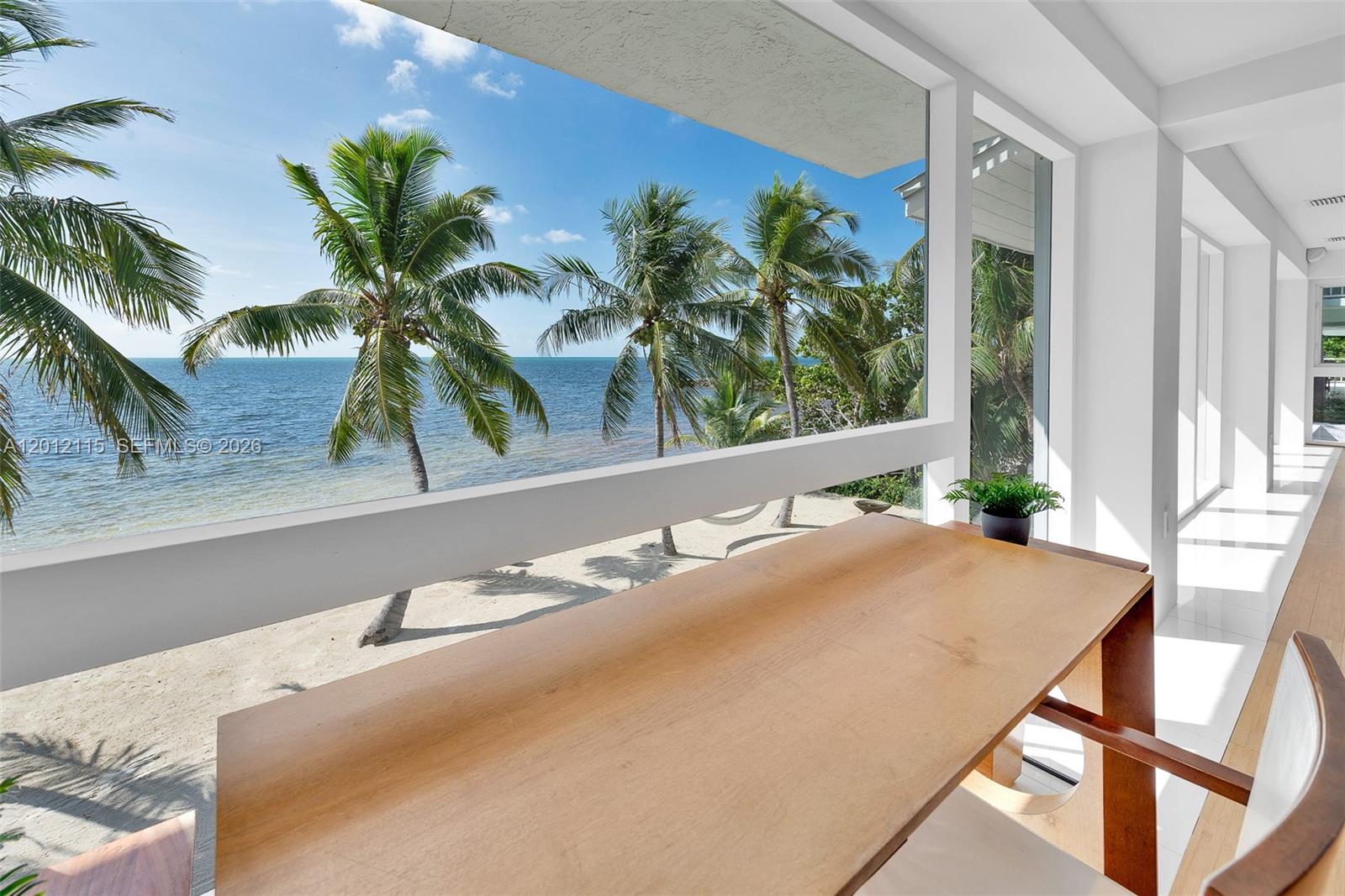 60 Ocean Front Drive Key Largo, FL 33037 - Photo 64 of 85 a dining room with furniture and a potted plant