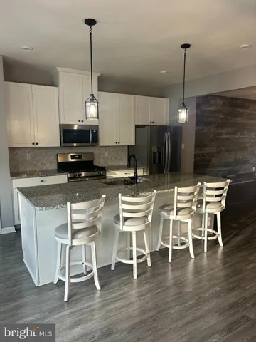 a view of a room with wooden floor windows and a kitchen view