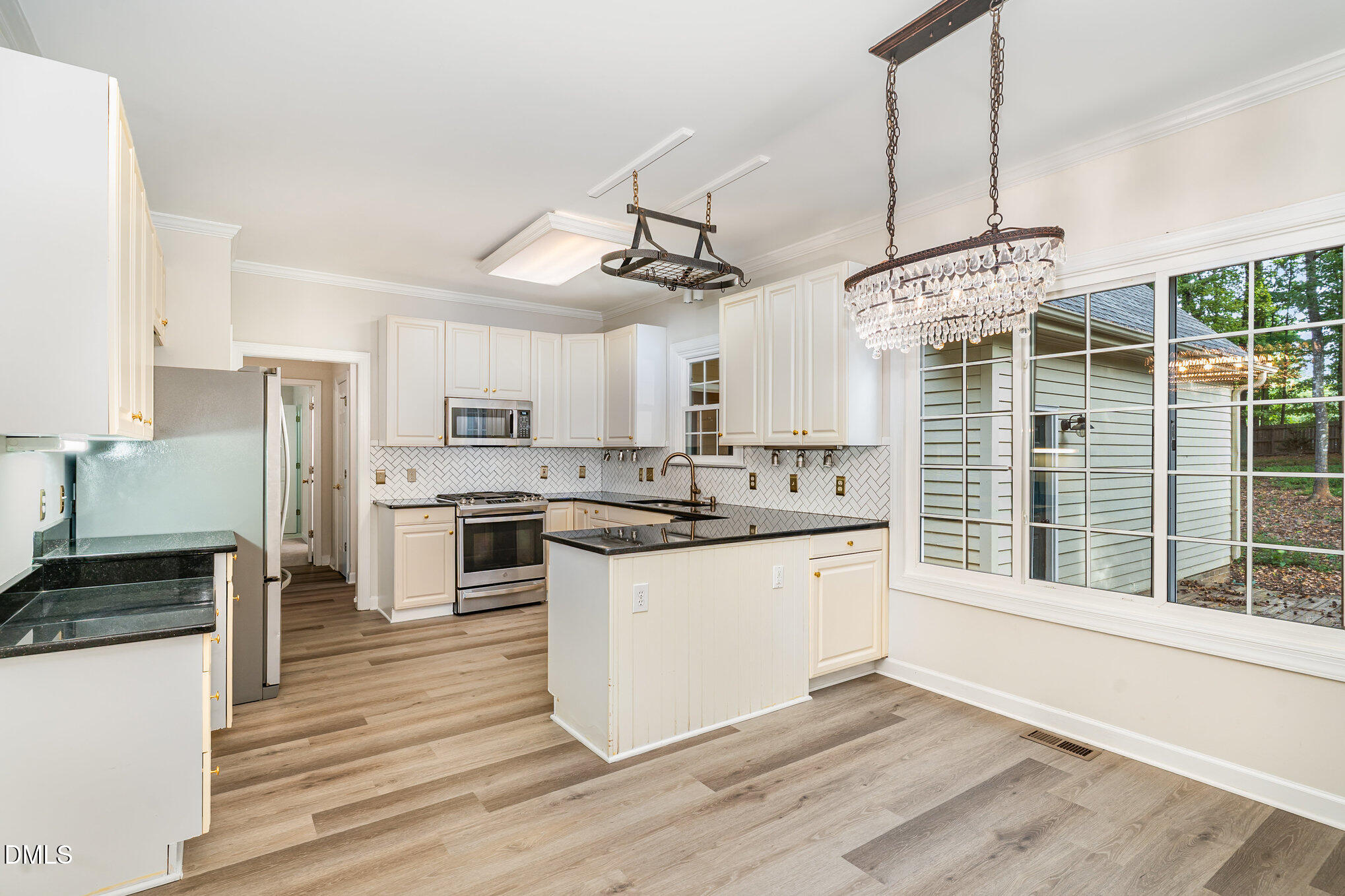 2425 Welsh Tavern Way Wake Forest, NC 27587 - Photo 9 of 34 a kitchen with stainless steel appliances granite countertop a stove and white cabinets with wooden floor