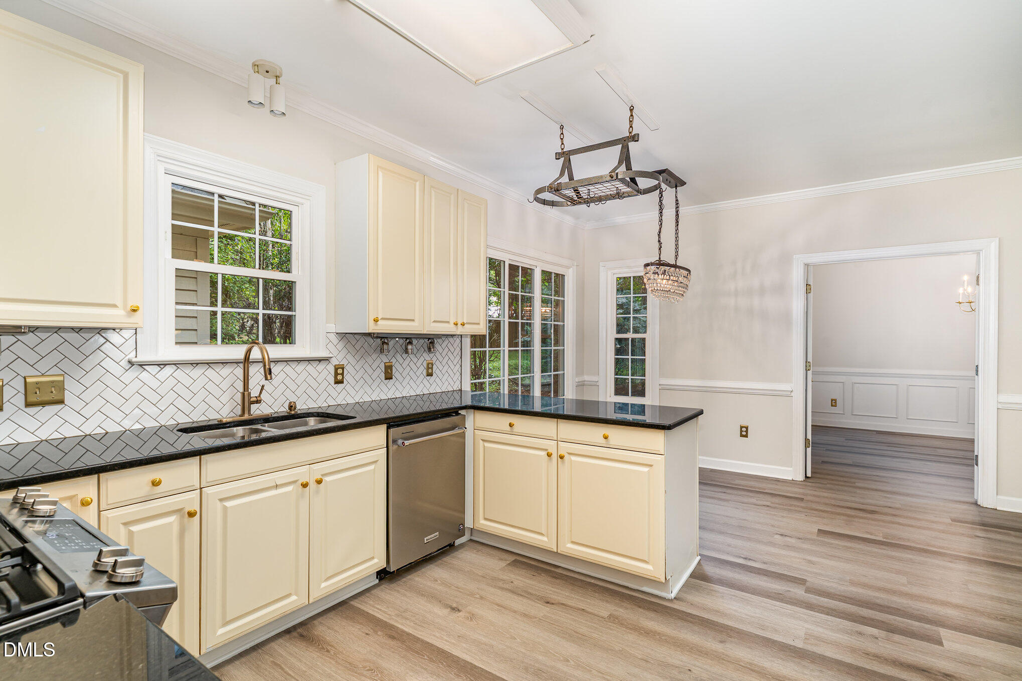2425 Welsh Tavern Way Wake Forest, NC 27587 - Photo 10 of 34 a kitchen with granite countertop a sink cabinets wooden floor and stainless steel appliances