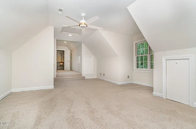 an empty room with windows and ceiling fan