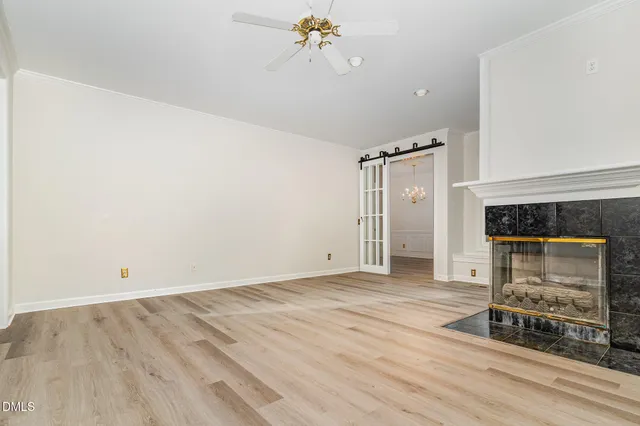 a view of an empty room with a fireplace and a window