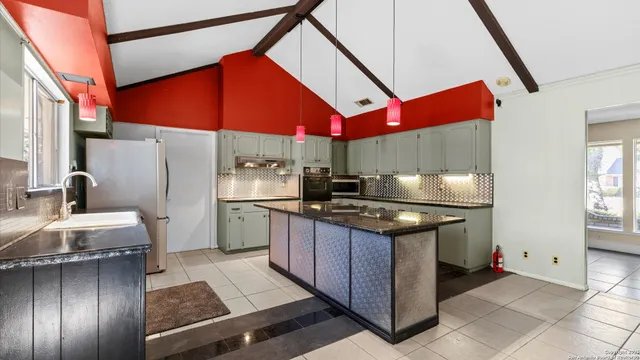 a kitchen with stainless steel appliances granite countertop a stove a sink and a refrigerator