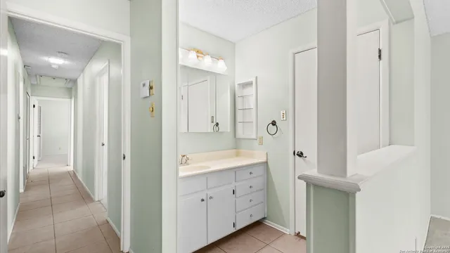 a spacious bathroom with a glass door shower a sink and a mirror