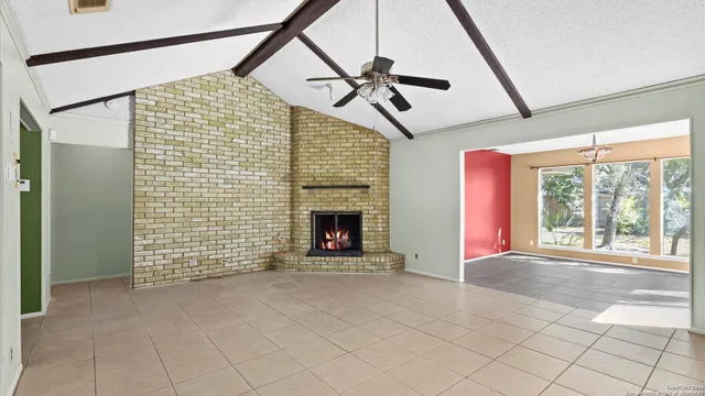 a view of an empty room with a fireplace and a window