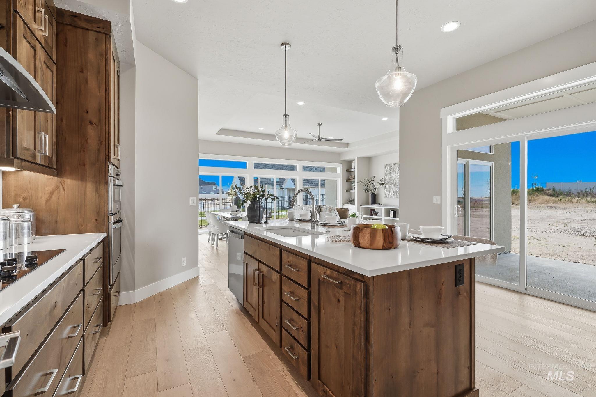 470 South Radiator Way Boise, ID 83716 - Photo 26 of 50 Gourmet kitchen featuring a wood-finish island with a white solid surface countertop and undermount sink, complemented by pendant lighting