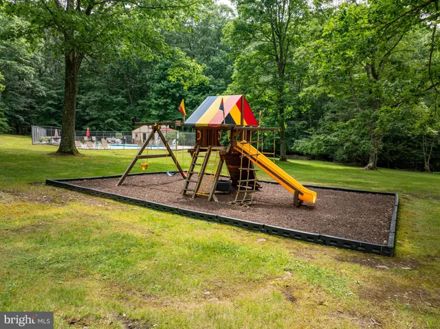 a park with a slide and large trees