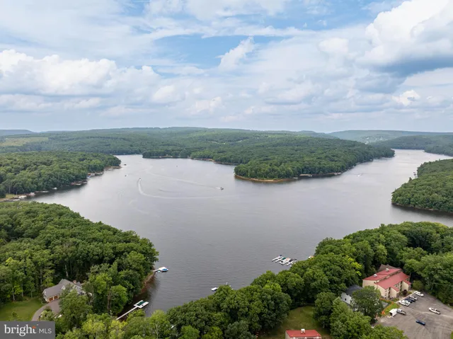 an aerial view of lake and residential houses with outdoor space