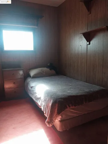 a bedroom with a bed and a night stand