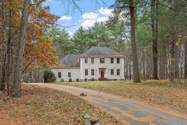 a white house with a large tree in front of it