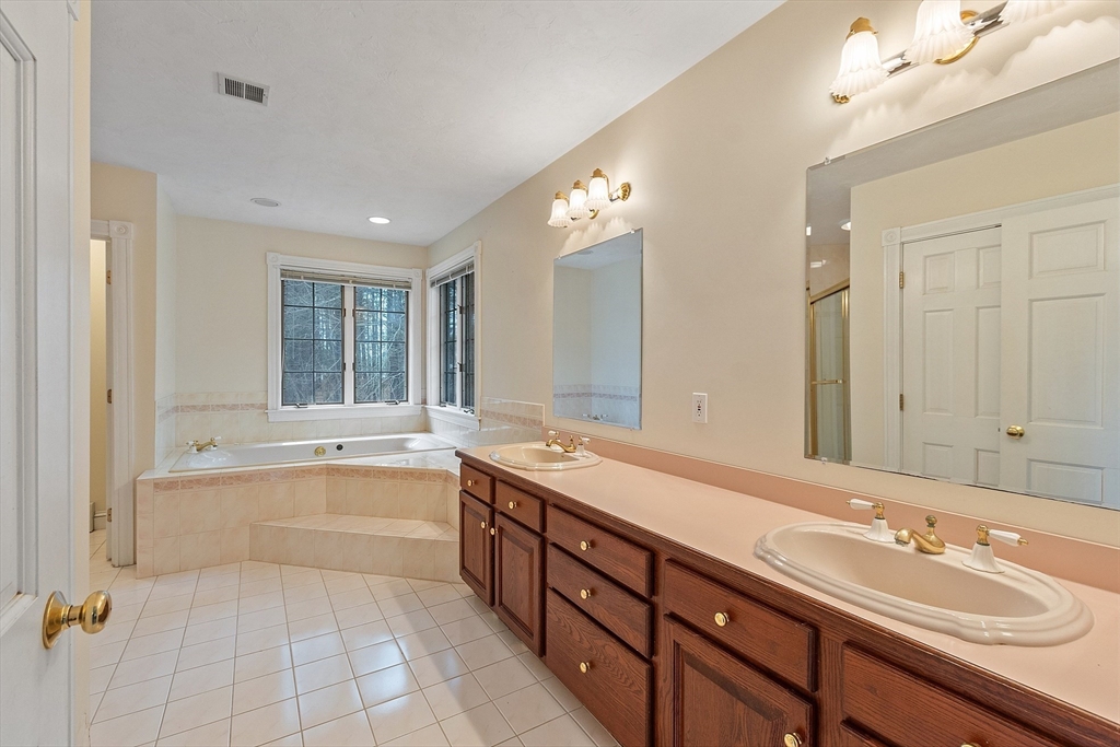 96 Cedarwood Road Boxborough, MA 01719 - Photo 23 of 41 a spacious bathroom with a double vanity sink large mirror and a bathtub
