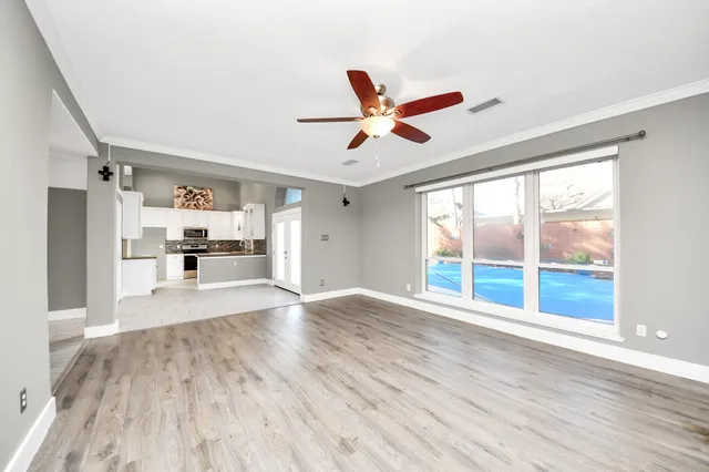 a view of a kitchen with wooden floor and a ceiling fan