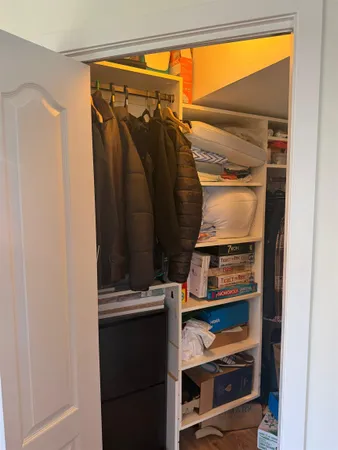 a view of walk in closet with clothes and shoes