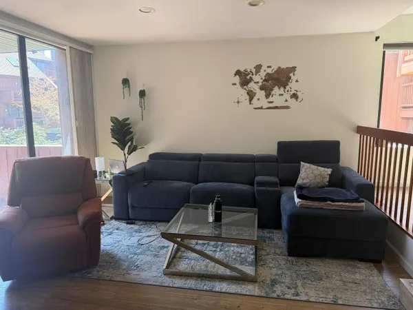 a living room with furniture and a window with garden view