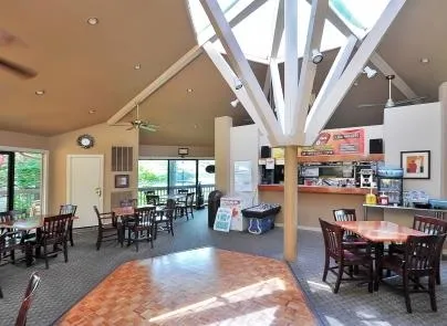 a dining hall with lots of tables a large window and chairs