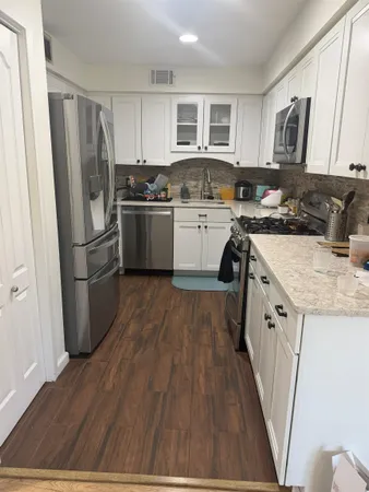 a kitchen with a sink a refrigerator a stove a microwave and cabinets