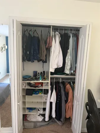 a view of walk in closet with clothes and shoes