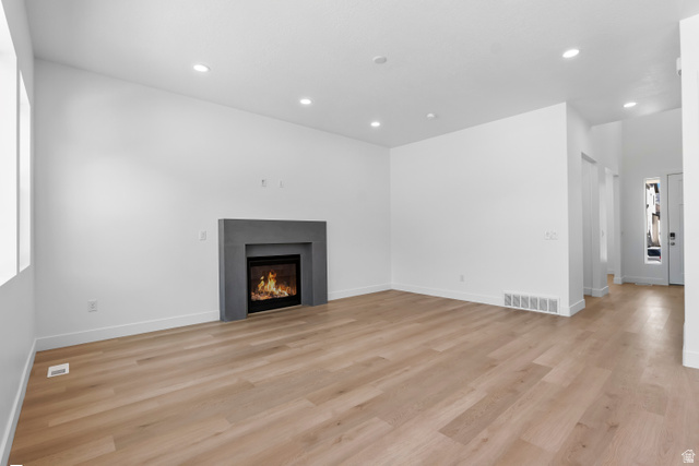 36 South Crimson Way, Unit 305 Mapleton, UT 84664 - Photo 2 of 7 Spacious room featuring light wood-finish flooring, recessed lighting, and a modern dark gray fireplace surround