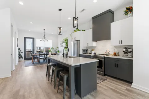 a kitchen with stainless steel appliances kitchen island wooden floors and wooden cabinets